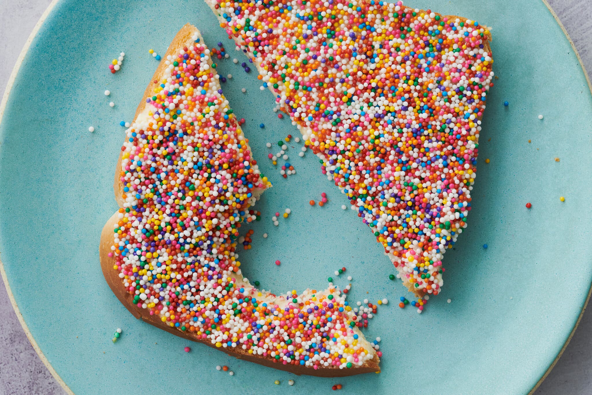 An overhead image of two bread triangles topped with multicolored sprinkles.