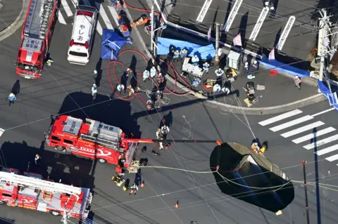 Reuters An aerial view shows rescue operations underway at a large sinkhole that swallowed a truck at an intersection in Yashio, north of Tokyo, Japan January 28, 2025