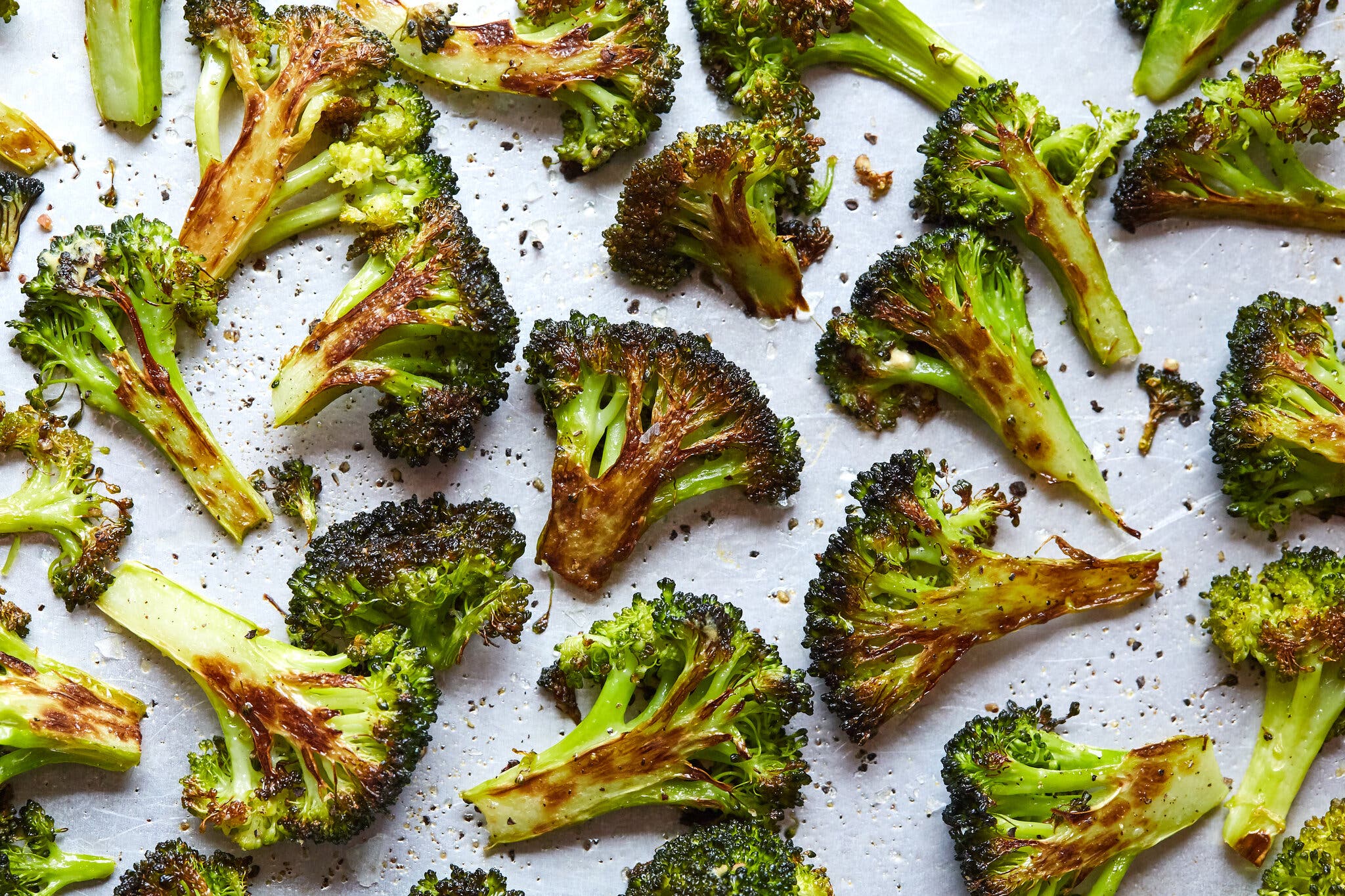 An overhead image of roasted broccoli florets on a pan.