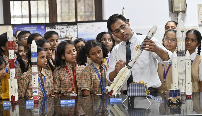 An instructor explains different missions of the ISRO to students.