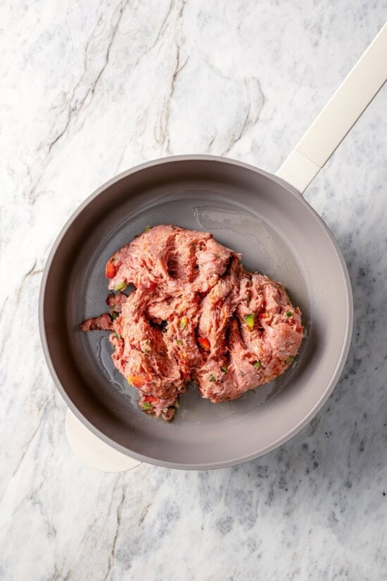 This hearty white bean soup with turkey sausage and kale is packed with protein and fiber, full of cozy flavor, and perfect for chilly days! Turkey sausage added to pot with olive oil.