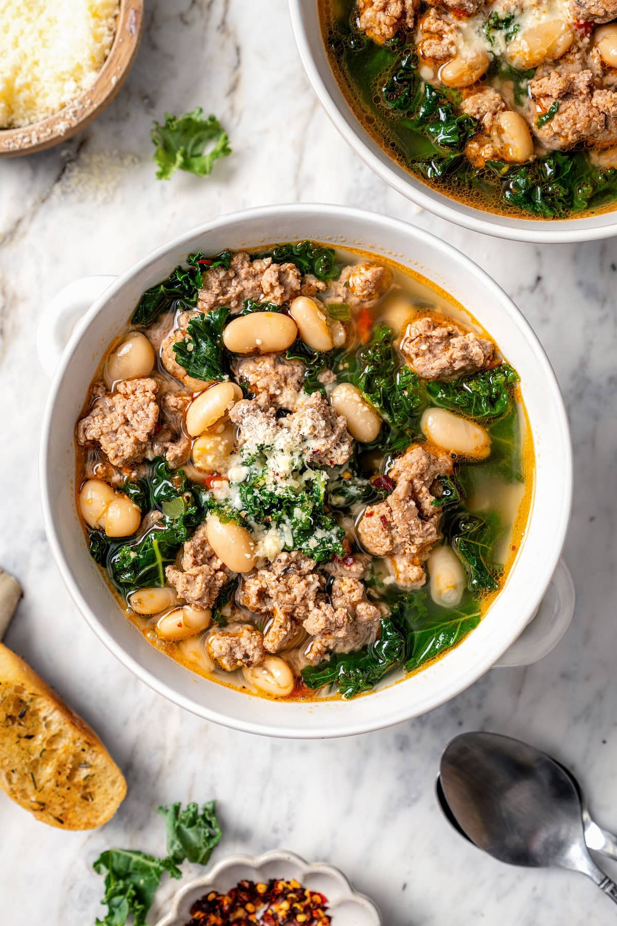 This hearty white bean soup with turkey sausage and kale is packed with protein and fiber, full of cozy flavor, and perfect for chilly days! Bowl of white bean soup with sausage and kale.